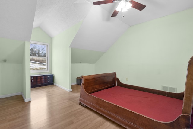 bedroom with ceiling fan, vaulted ceiling, and light hardwood / wood-style flooring