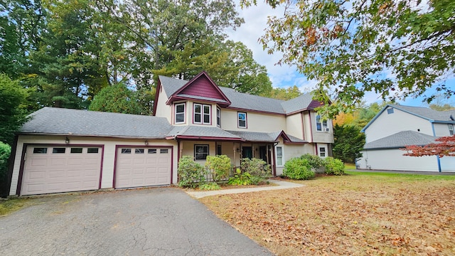 victorian-style house featuring a garage and a front yard