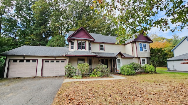 view of front of home with a front lawn, covered porch, and a garage