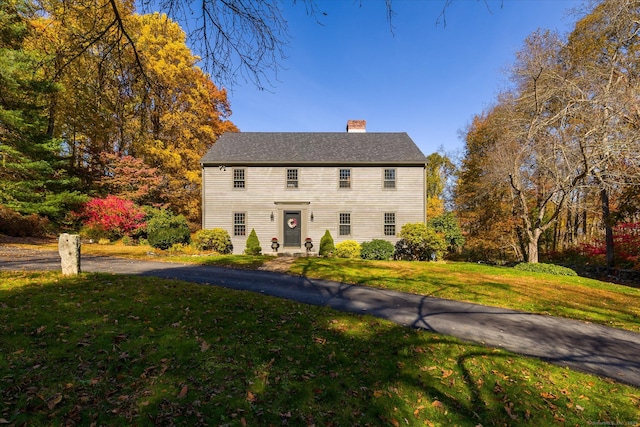 colonial house featuring a front lawn