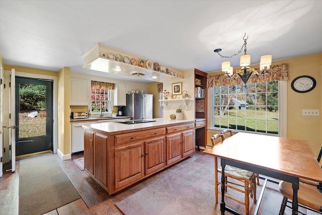 kitchen featuring hanging light fixtures, white dishwasher, a healthy amount of sunlight, and light hardwood / wood-style flooring