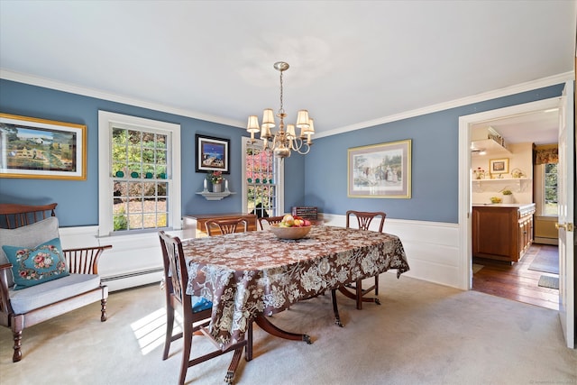 dining room featuring a healthy amount of sunlight, a baseboard heating unit, and crown molding