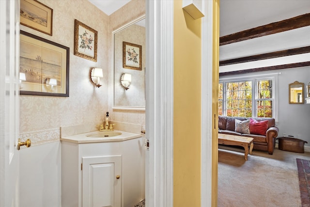 bathroom with vanity and beam ceiling