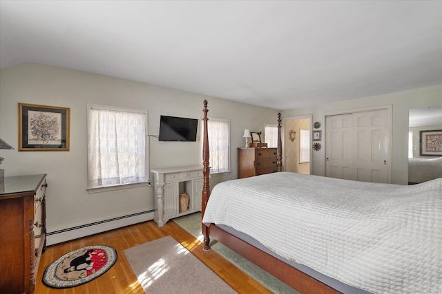 bedroom with light hardwood / wood-style flooring, a closet, and a baseboard radiator