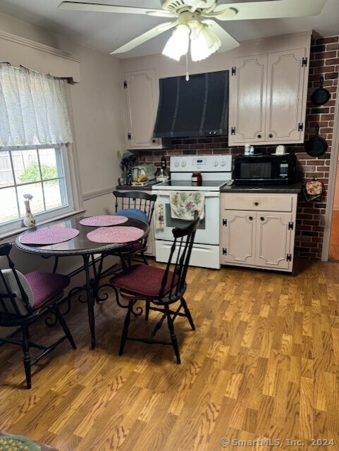 kitchen with white cabinetry, light hardwood / wood-style floors, white range with electric cooktop, and ventilation hood