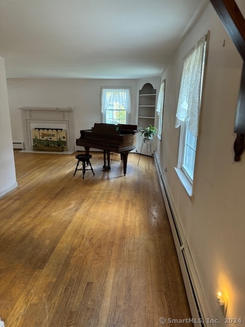 miscellaneous room with baseboard heating and hardwood / wood-style flooring