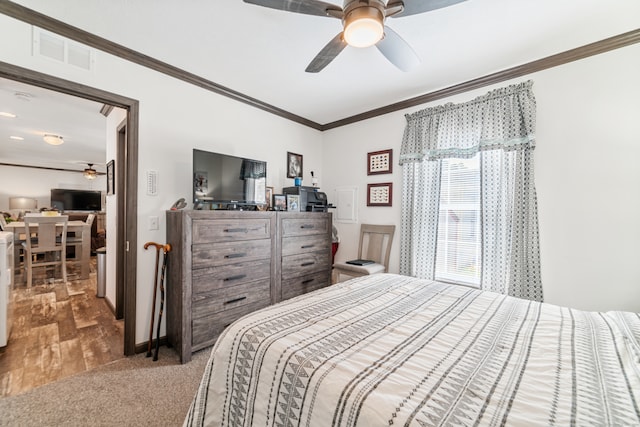 bedroom with ceiling fan, crown molding, and wood-type flooring