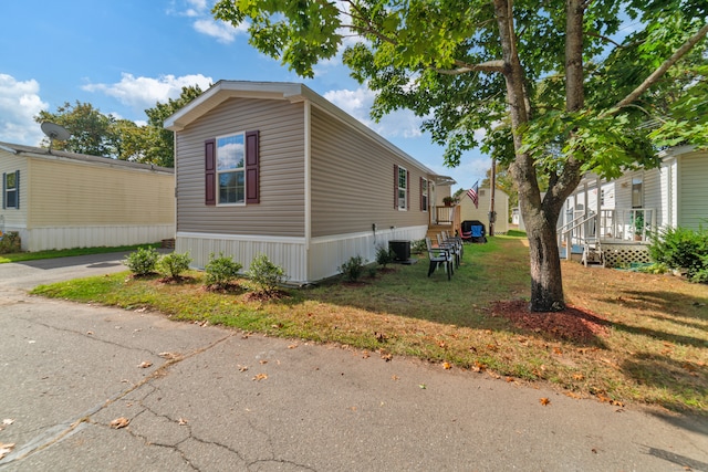 view of home's exterior featuring a yard and central AC