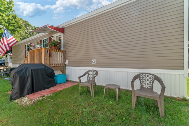 view of side of home featuring a deck and a lawn