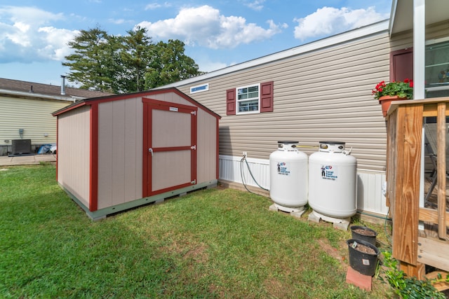 view of outdoor structure with a lawn and central air condition unit