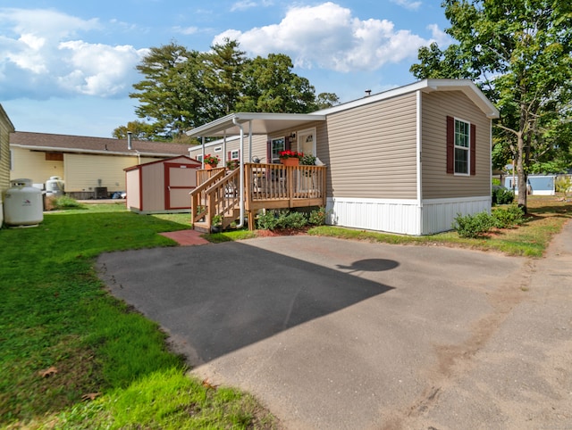 manufactured / mobile home featuring a front lawn and a shed