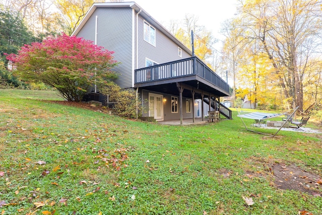 rear view of house featuring a yard, a patio, and a deck