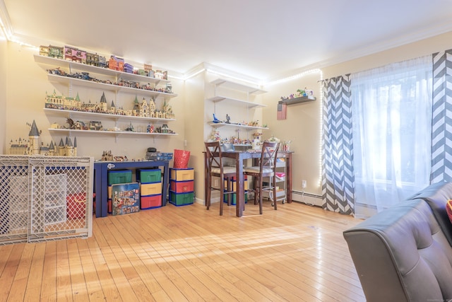 interior space with baseboard heating, ornamental molding, and light wood-type flooring