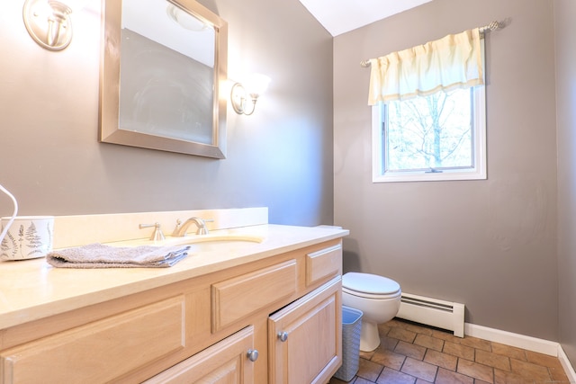 bathroom with vanity, a baseboard heating unit, and toilet