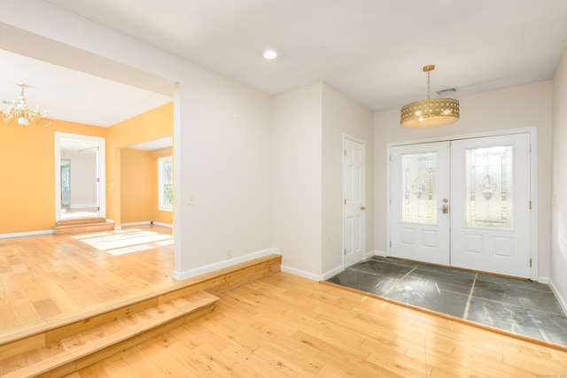 entryway with a notable chandelier, hardwood / wood-style floors, and french doors