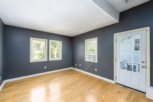 unfurnished room with cooling unit and light wood-type flooring