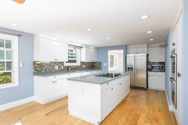 kitchen featuring stainless steel appliances, white cabinets, and a kitchen island