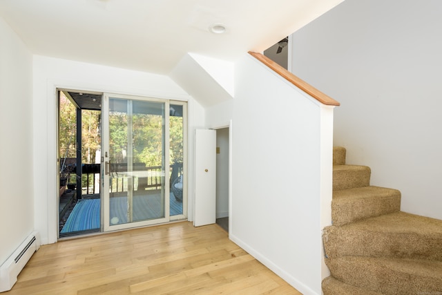 doorway featuring light wood-type flooring and a baseboard heating unit