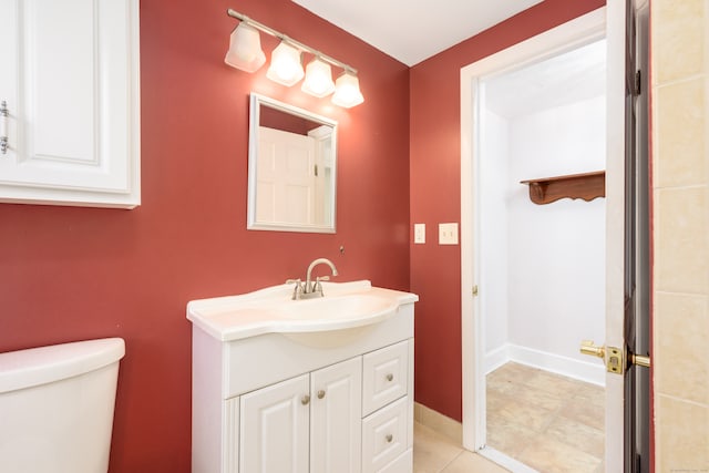 bathroom featuring tile patterned flooring, vanity, and toilet