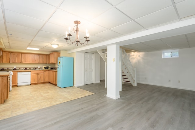 kitchen featuring light wood-type flooring, a paneled ceiling, white appliances, and decorative light fixtures