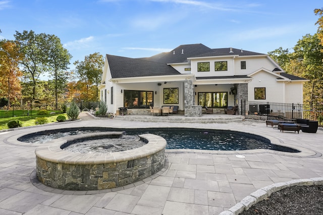 back of house featuring a patio and a swimming pool with hot tub