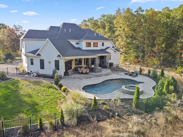 rear view of property featuring a swimming pool with hot tub and a patio