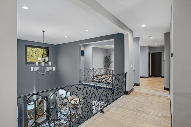 hallway with a notable chandelier and light hardwood / wood-style flooring