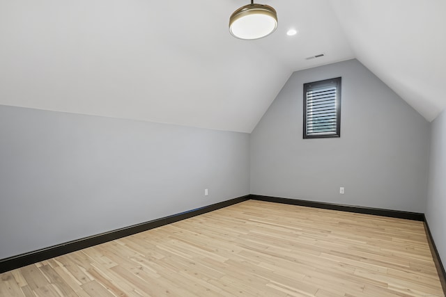 additional living space with lofted ceiling and light hardwood / wood-style flooring