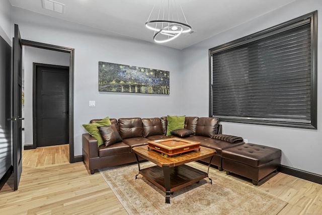 living room with a notable chandelier and light hardwood / wood-style flooring