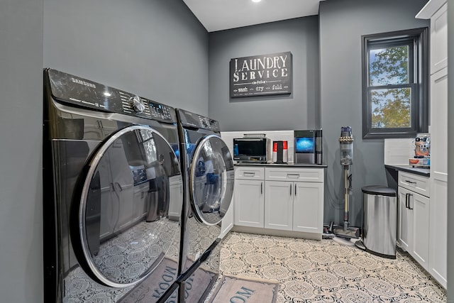 washroom with cabinets and washer and clothes dryer