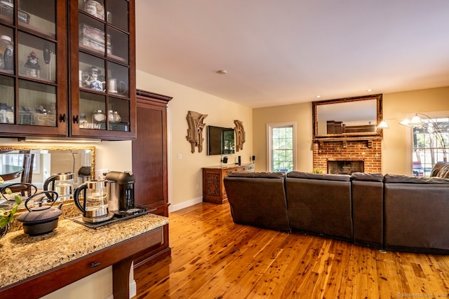 living room featuring light wood-type flooring and a fireplace