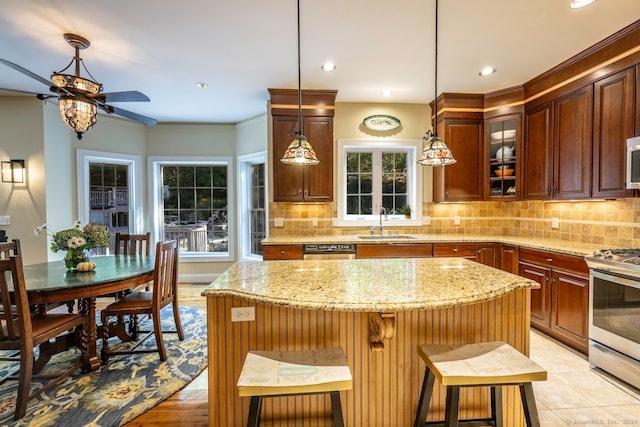 kitchen with stainless steel appliances, decorative backsplash, a center island, and a kitchen breakfast bar