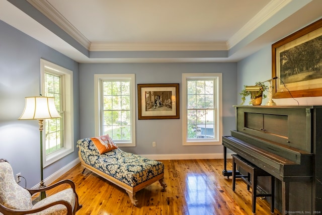 sitting room with light hardwood / wood-style floors, ornamental molding, and a healthy amount of sunlight