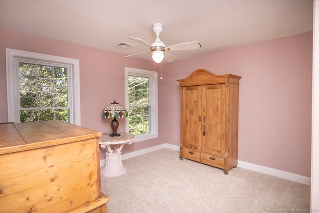 interior space with ceiling fan, light colored carpet, and a wealth of natural light