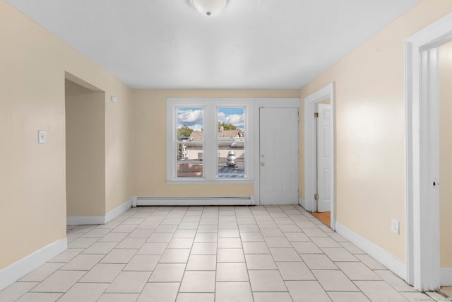 empty room featuring light tile patterned flooring and a baseboard radiator