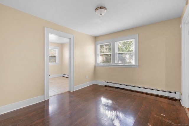 spare room featuring wood-type flooring and baseboard heating