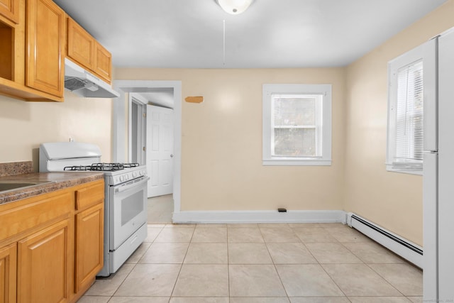 kitchen featuring white gas range oven, a healthy amount of sunlight, light tile patterned floors, and baseboard heating