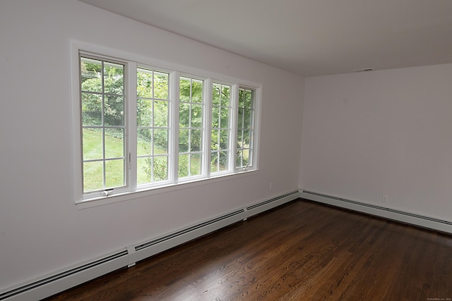 empty room with a baseboard heating unit and dark wood-type flooring