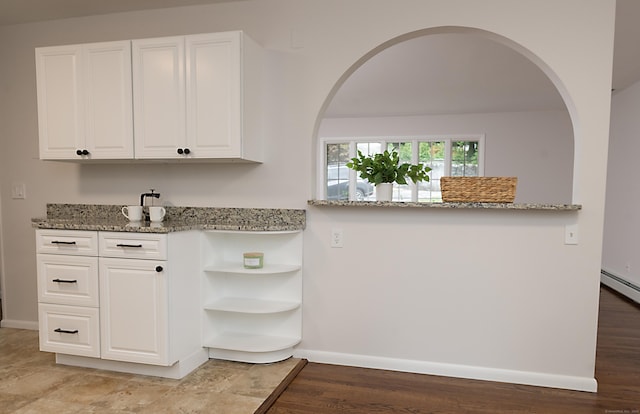 kitchen featuring white cabinetry and light stone counters