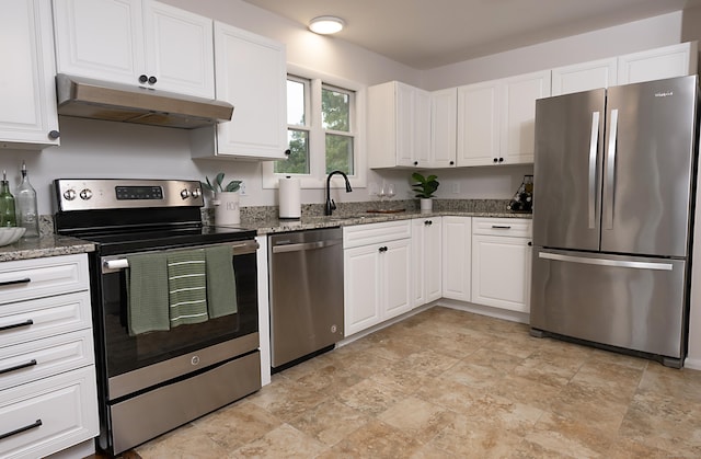 kitchen with stone counters, white cabinetry, appliances with stainless steel finishes, and sink