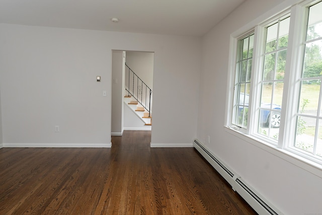 unfurnished room featuring dark hardwood / wood-style flooring, a wealth of natural light, and baseboard heating