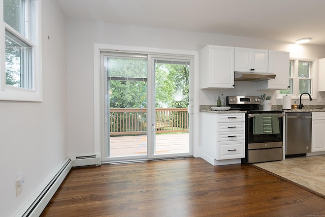 kitchen with dark wood-type flooring, white cabinetry, stone countertops, baseboard heating, and stainless steel appliances