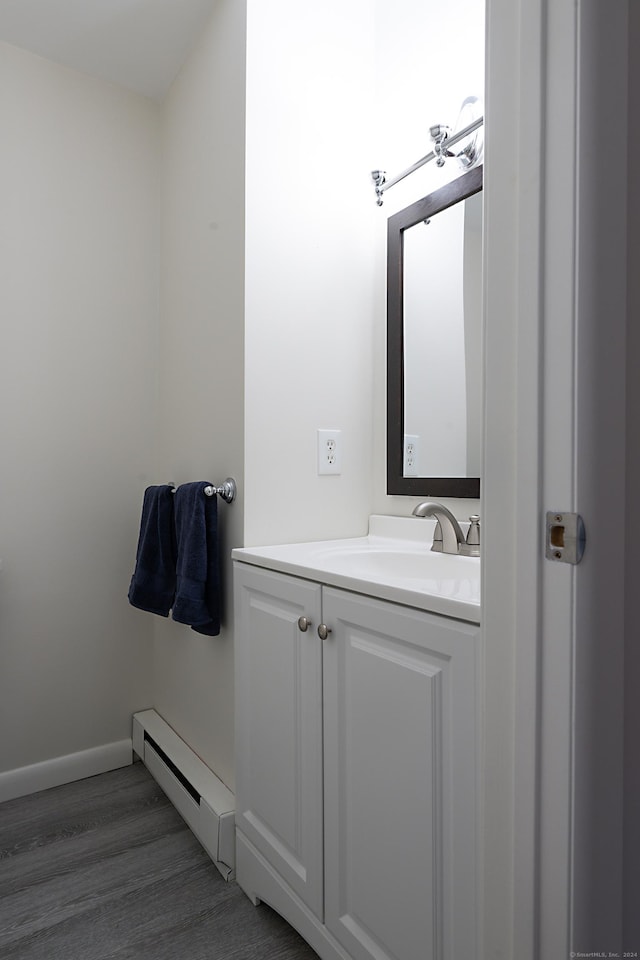 bathroom with vanity, a baseboard radiator, and wood-type flooring