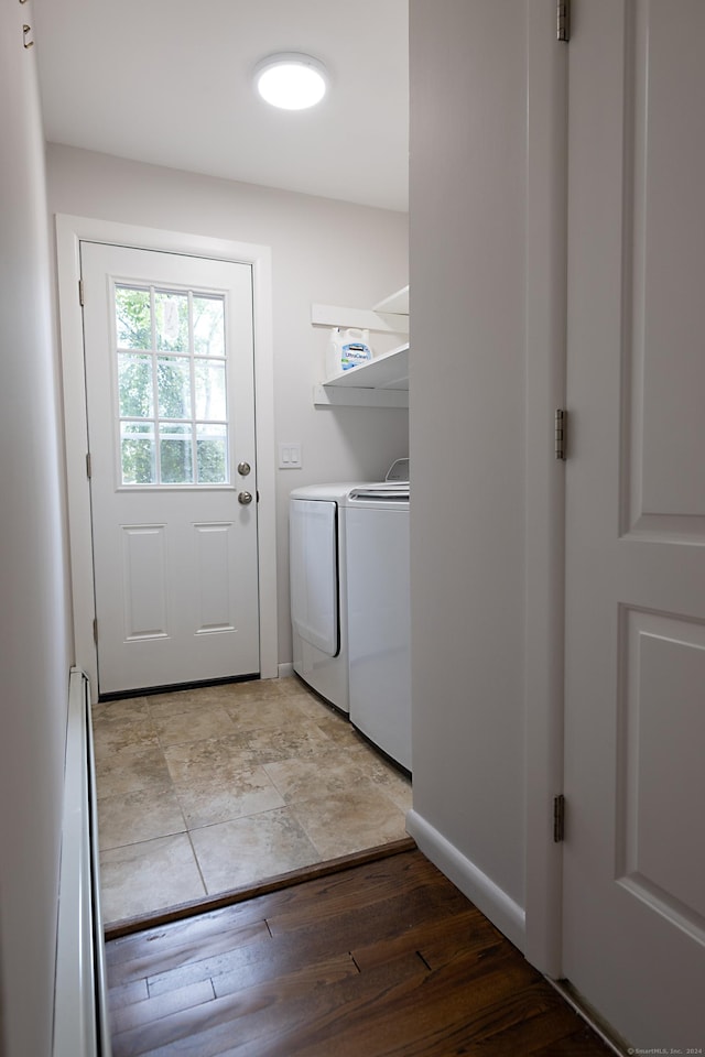 laundry room with washing machine and dryer and light hardwood / wood-style floors