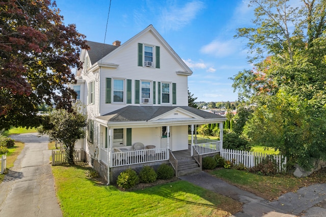 view of front of house with a porch and a front yard