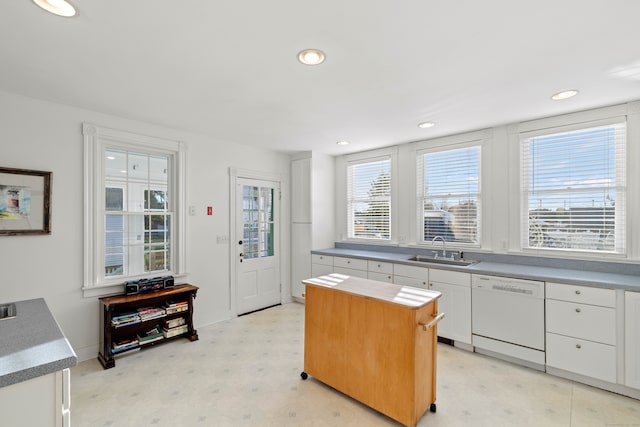 kitchen featuring sink, white cabinetry, a center island, and dishwasher