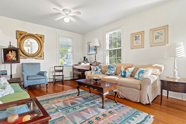 living room with ceiling fan, hardwood / wood-style flooring, baseboard heating, and a healthy amount of sunlight