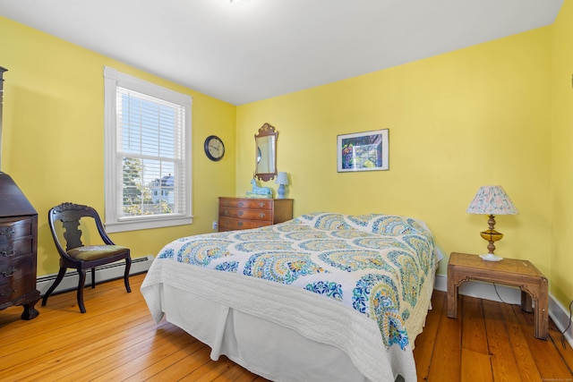 bedroom with hardwood / wood-style flooring and a baseboard heating unit