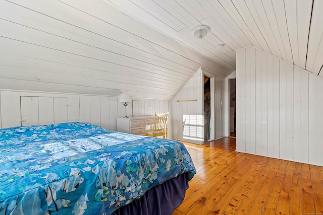 bedroom with wood walls, wood ceiling, lofted ceiling, and light wood-type flooring