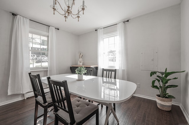 dining space with dark wood-type flooring, a healthy amount of sunlight, electric panel, and an inviting chandelier